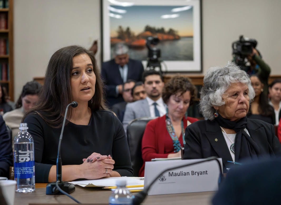 Maulian Bryant sitting at a desk speaking to a Congressional committee