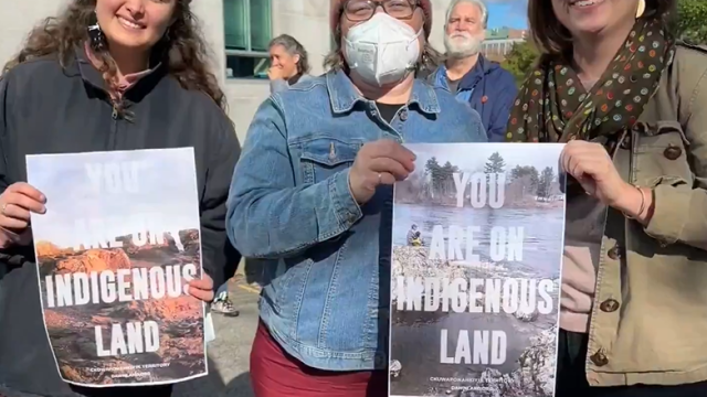 Photo: Anne Henshaw Three people holding signs with text You Are On Indigenous Land